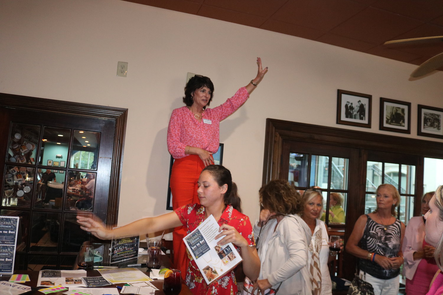 Ponte Vedra Women’s Club President Lori Marjerison (standing on a chair) speaks to the crowd in attendance.